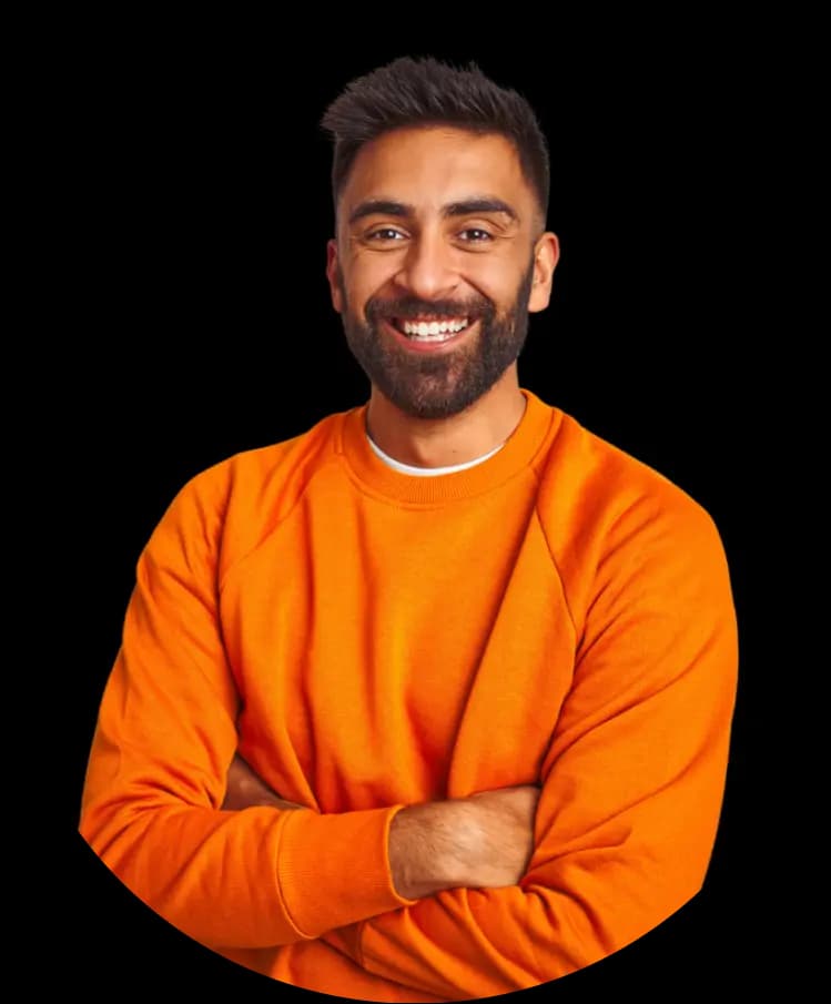 A man with medium skin tone and short dark hair, wearing an orange long-sleeve shirt. He has a friendly smile and a beard, standing with his arms crossed.